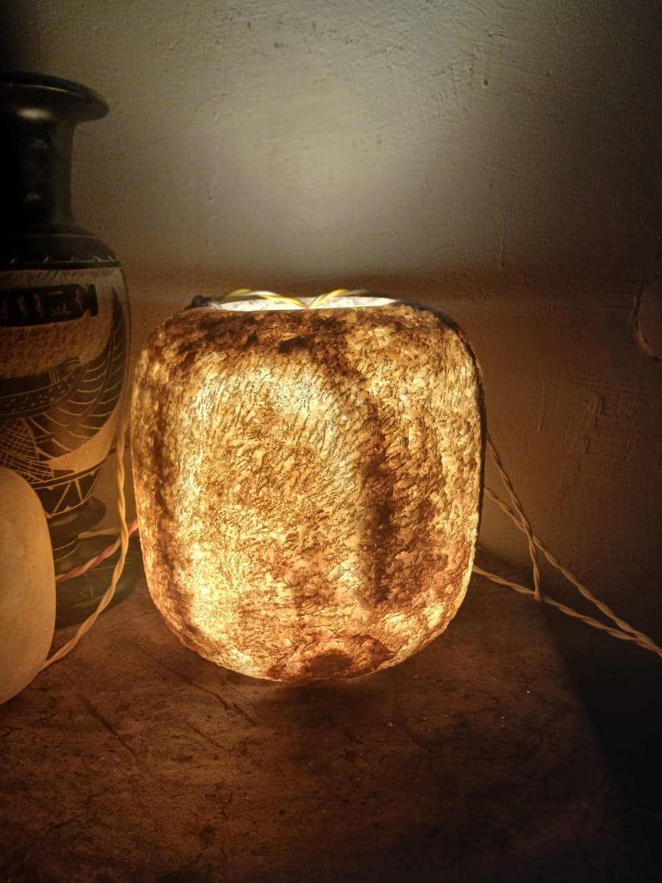 Low wide squat alabaster bedside lamp casting soft diffused gold illumination