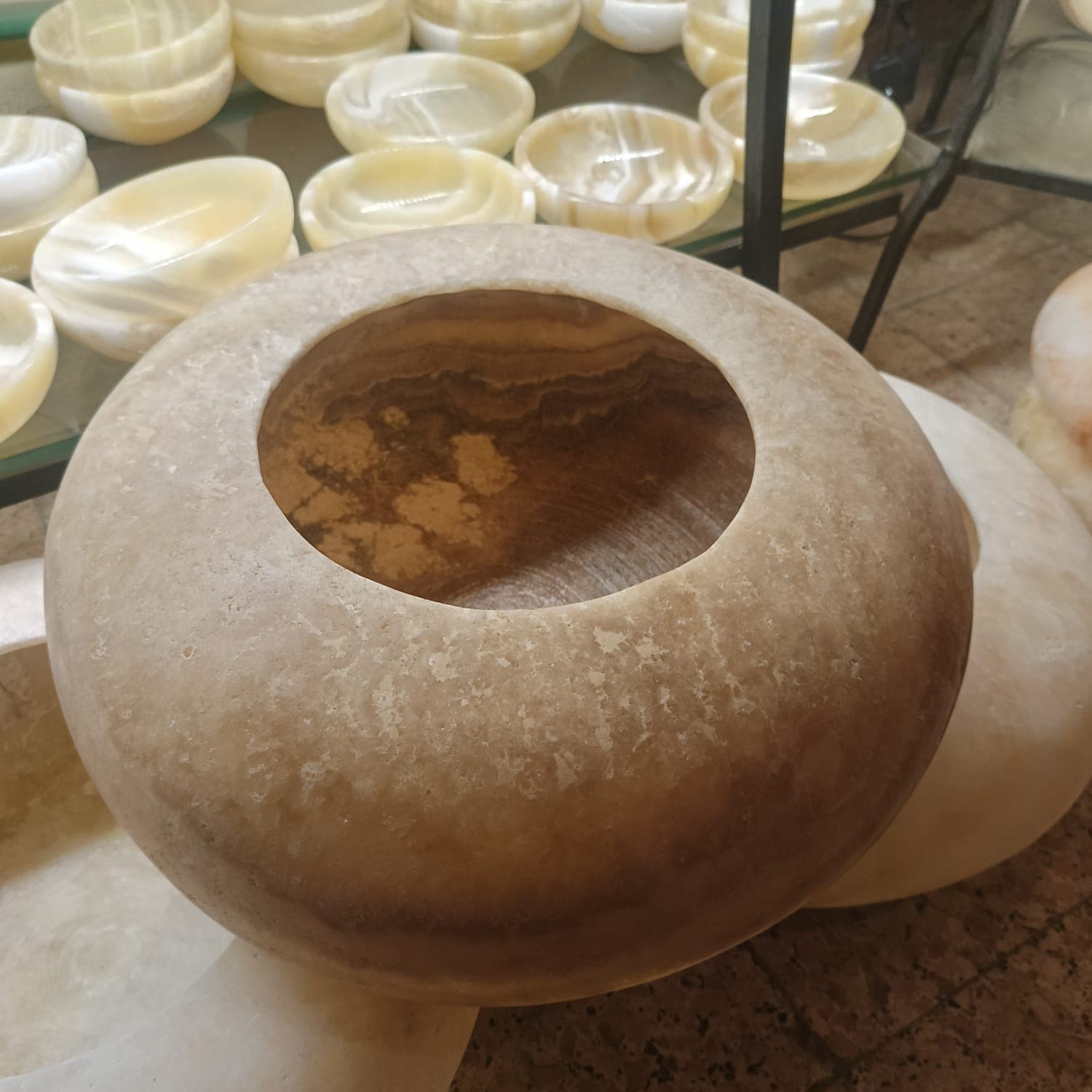 Large thick-rimmed hollowed spherical alabaster bowl showing dense geological layers