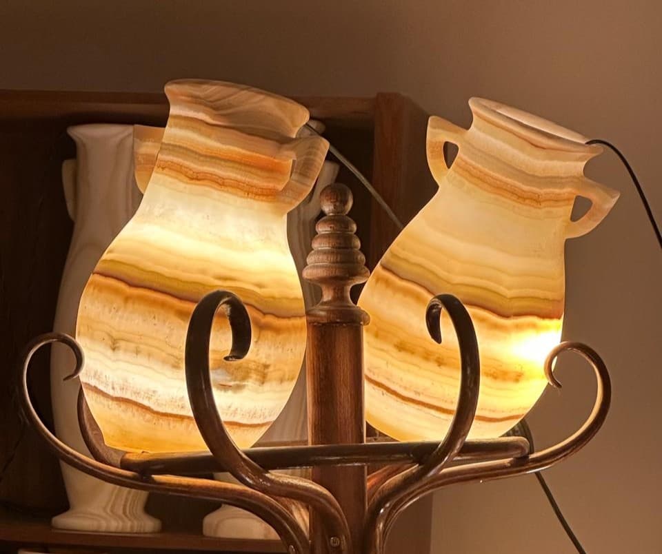 Standing alabaster bedside lamp casting soft diffused gold illumination