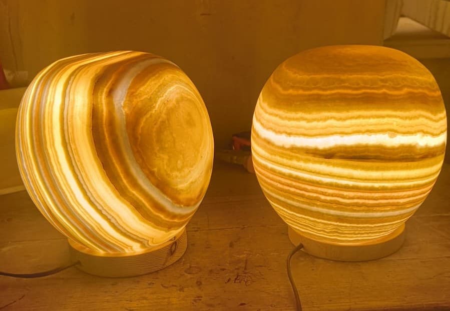 Tall oval handcrafted Egyptian alabaster table lamp glowing with warm amber light